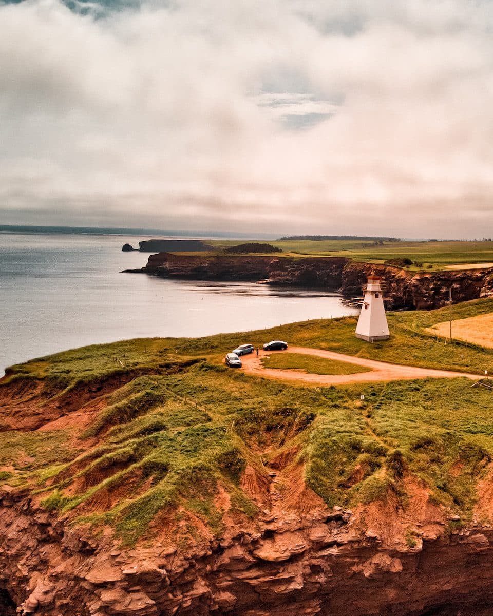 a lighthouse sitting on top of a lush green hillside